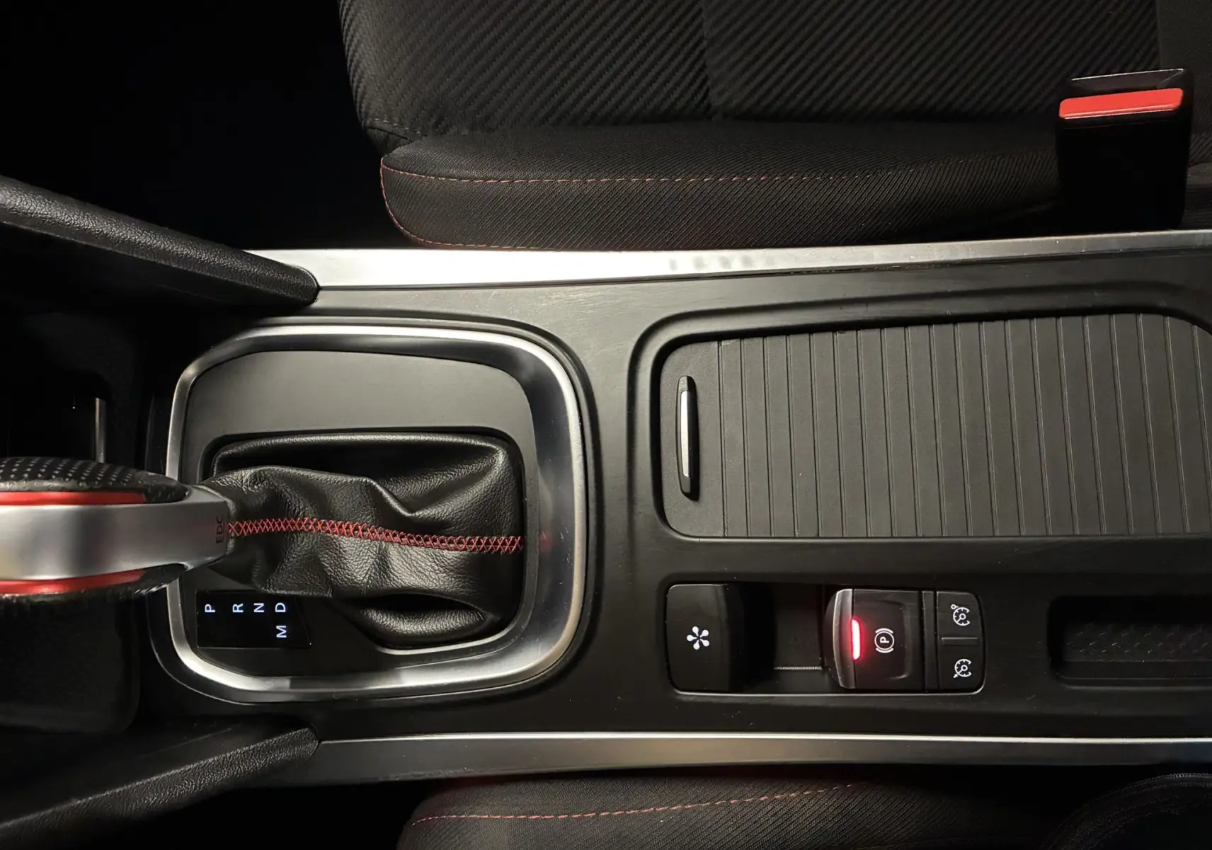 Vue plongeante sur la console centrale de la Renault Mégane IV RS 280 EDC6 avec levier de vitesse cuir noir et surpiqûres rouges.