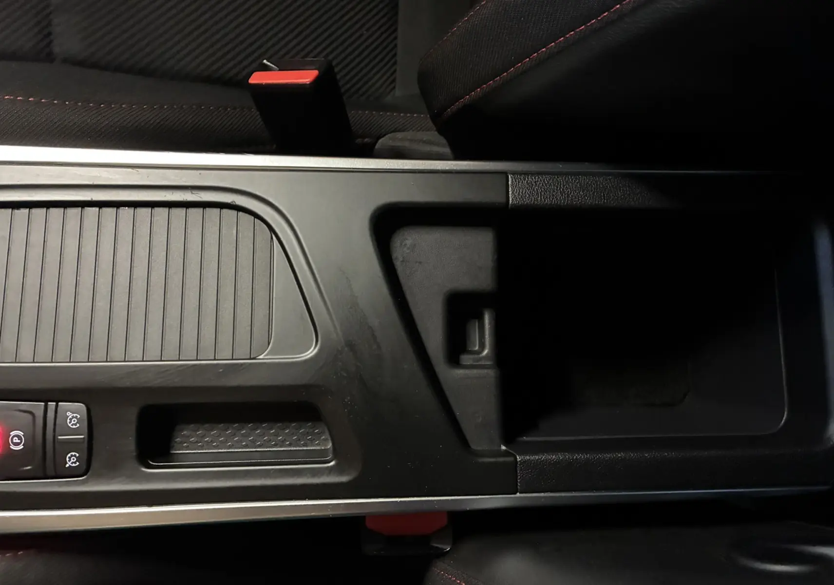 Vue rapprochée de la console centrale noire avec accoudoir et bouton de frein à main électronique de la Renault Mégane IV RS 280 EDC6.