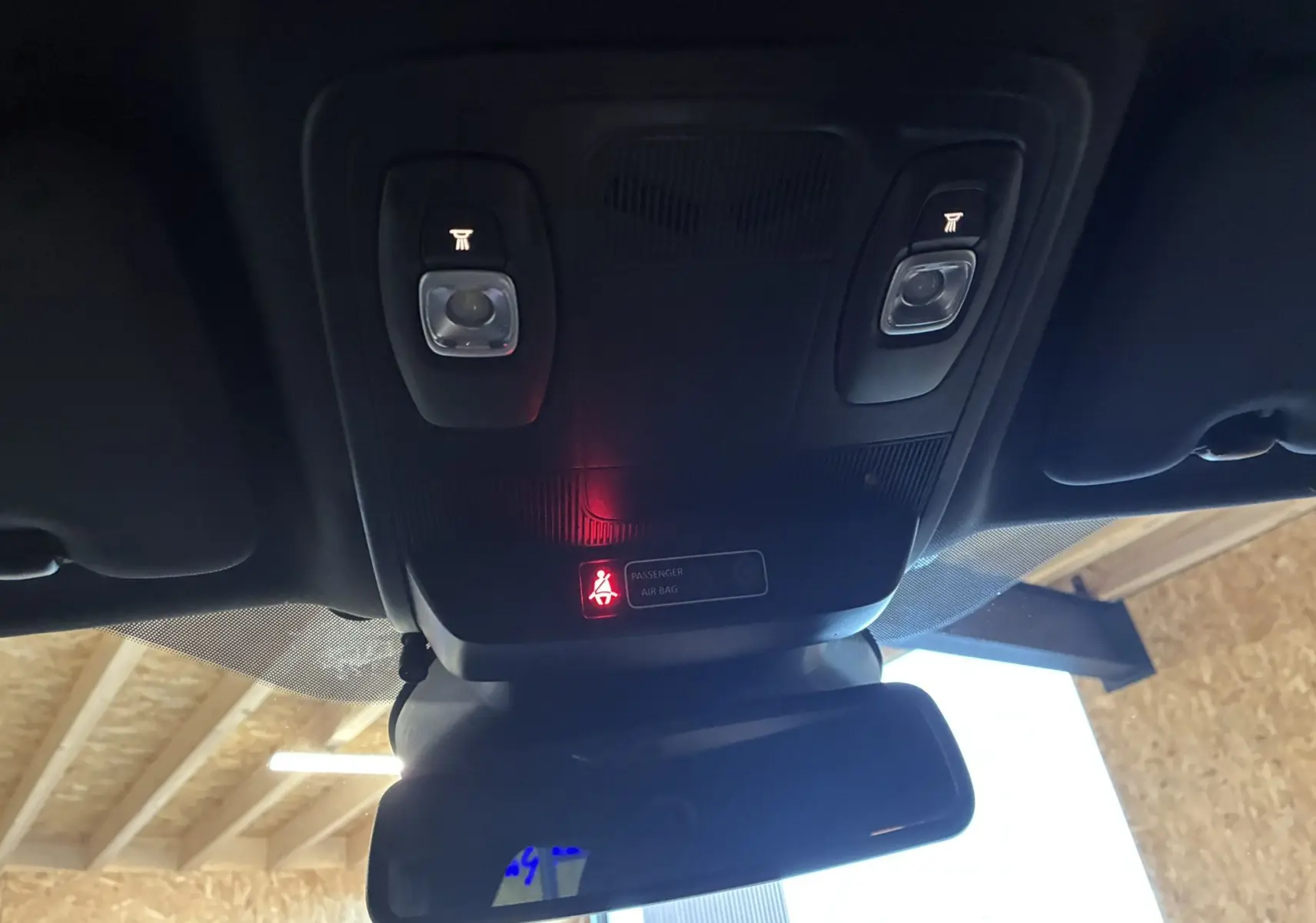 Vue intérieure du plafonnier et du rétroviseur d'une Renault Mégane IV RS 280 blanche, avec témoin de ceinture allumé.