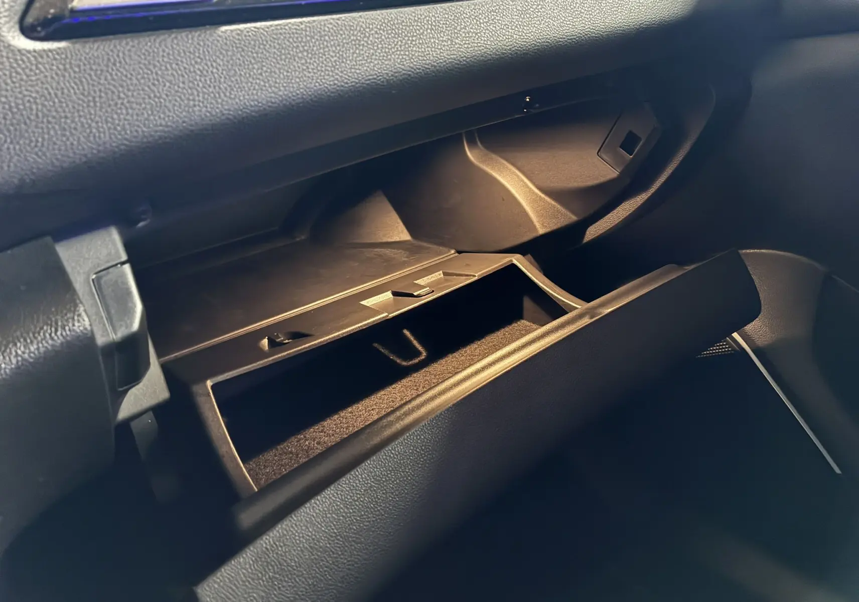 Vue rapprochée de la boîte à gants ouverte côté passager dans l’habitacle noir d’une Renault Mégane IV RS 280 EDC6 blanche.