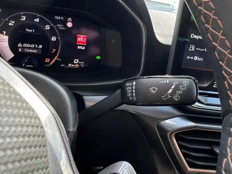 Gros plan sur la commande des essuie-glaces côté gauche du volant cuir du CUPRA Formentor gris, avec tableau de bord numérique.