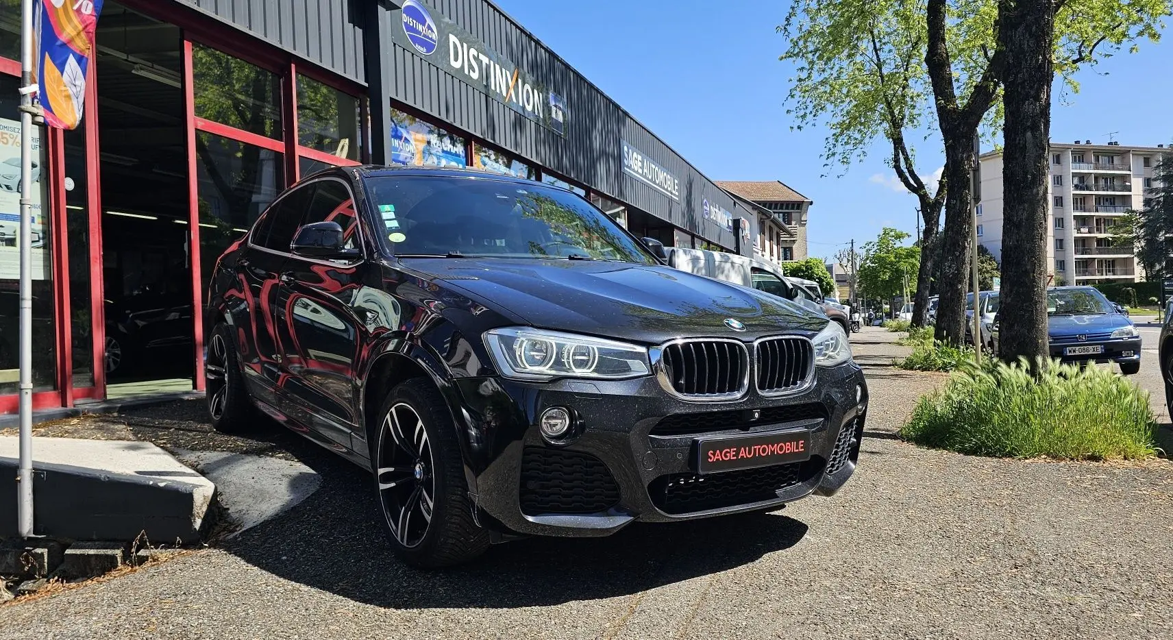 BMW X4 xDrive20dA noir en 3/4 avant droit, avec jantes sport et calandre caractéristique M Sport.