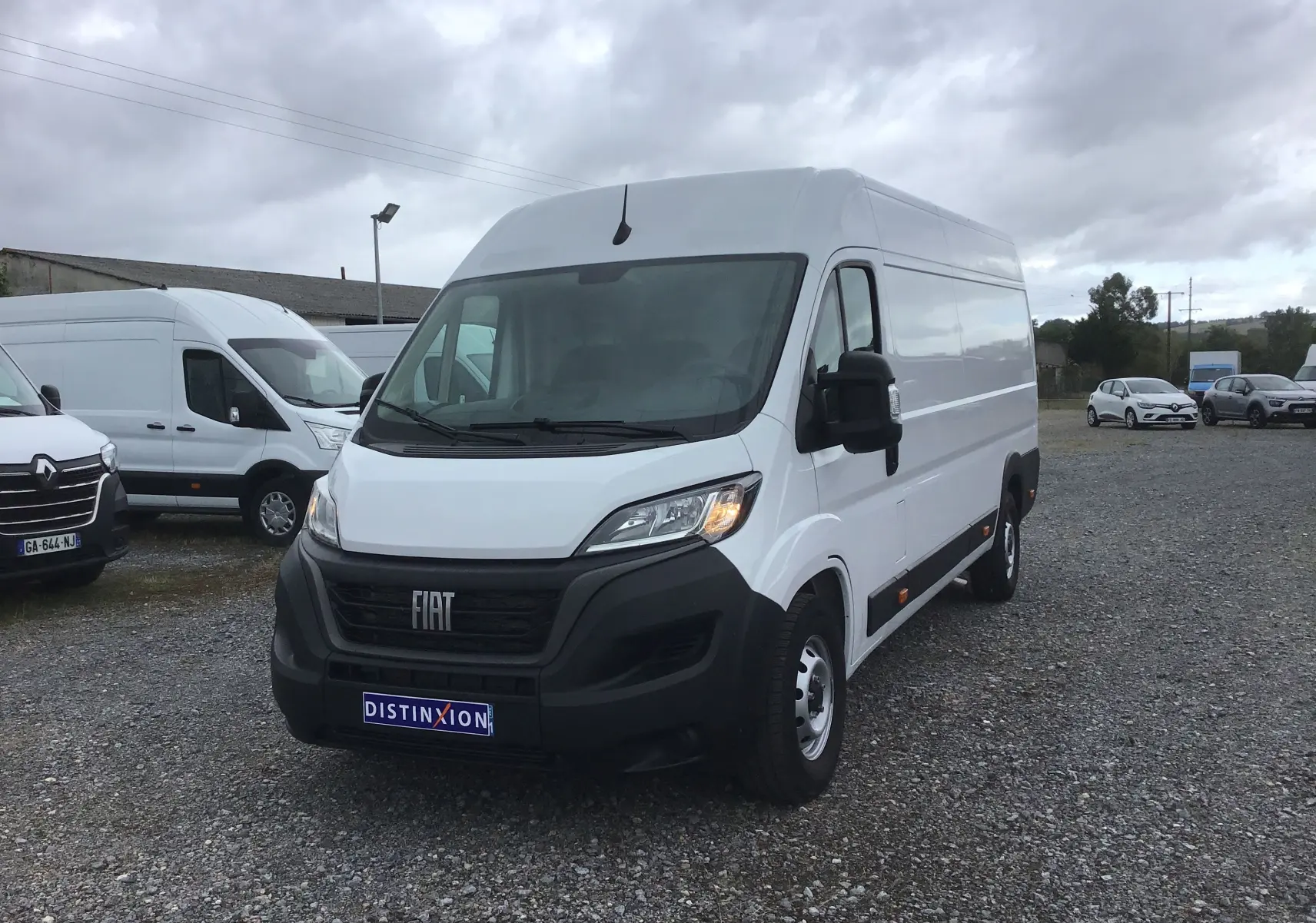 Fourgon blanc Fiat Ducato XLH2 3T5 vu en 3/4 avant droit sur un parking extérieur sous ciel nuageux.