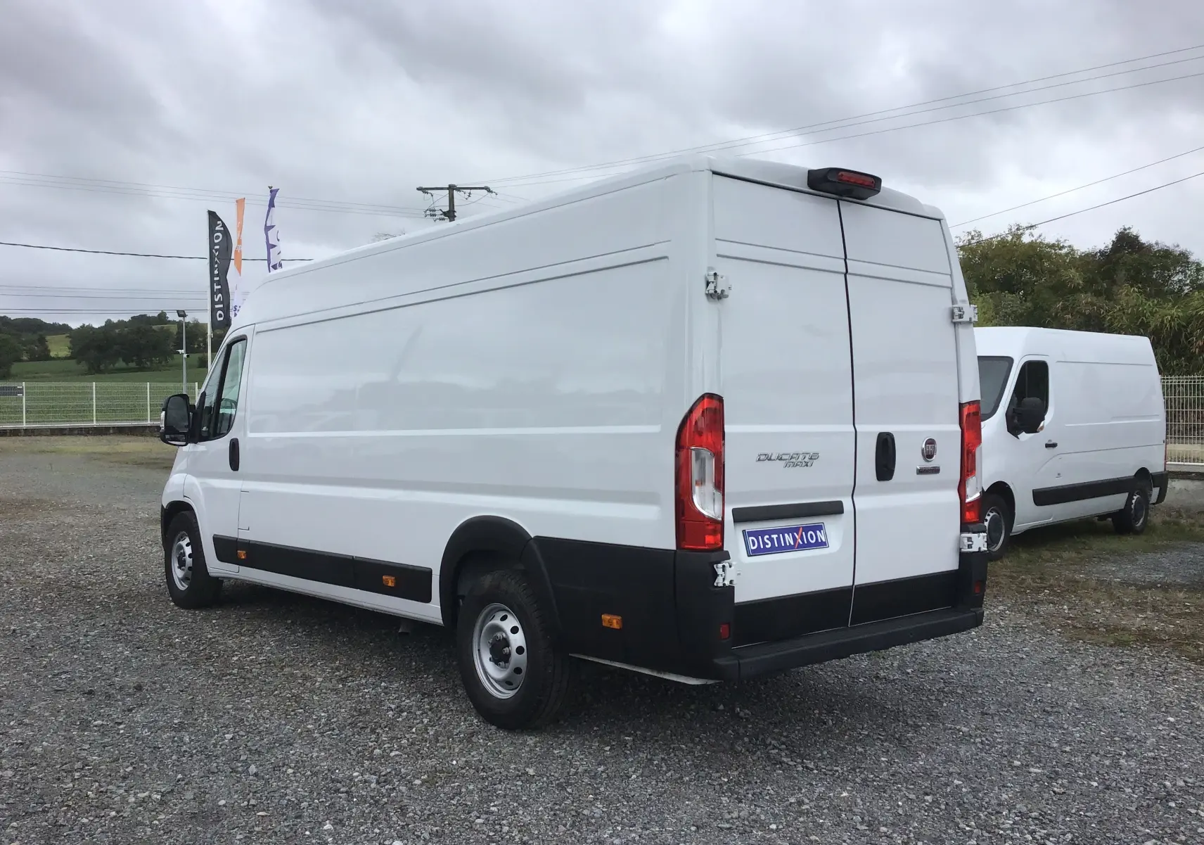 Fiat Ducato Fourgon blanc vu en 3/4 arrière droit, avec portes arrière fermées et pare-chocs noir.