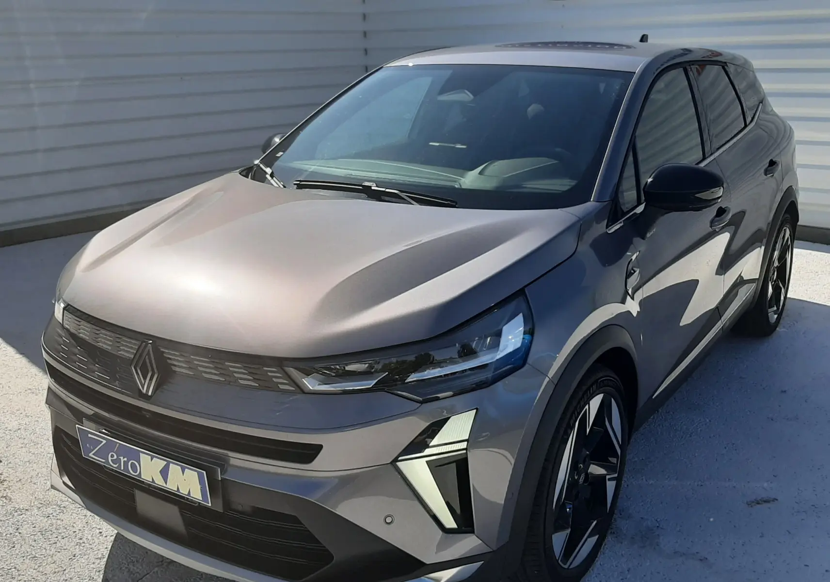 Vue 3/4 avant droite d'un Renault Symbioz gris cassiopée avec signature lumineuse LED et jantes noires distinctives.