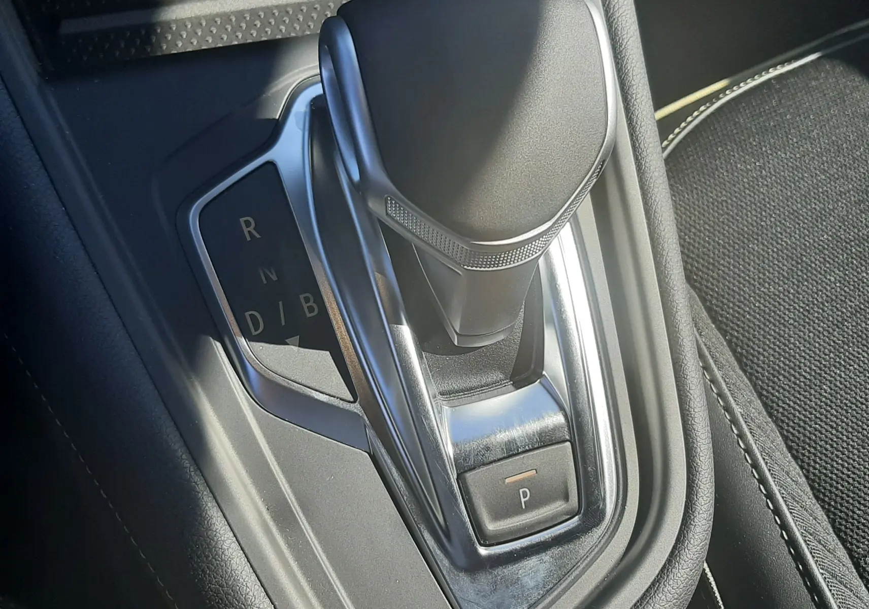 Le levier de vitesses automatique noir et chrome de la Renault Symbioz E-Tech, vu en gros plan intérieur.