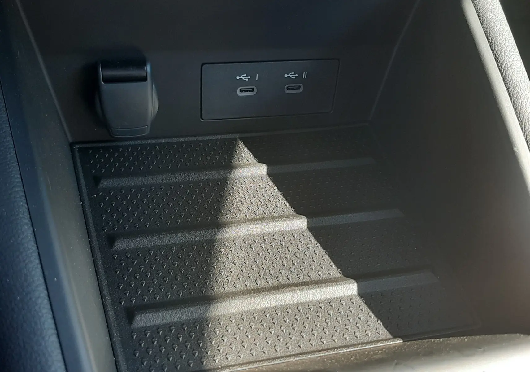 Gros plan sur la console centrale noire du Renault Symbioz 2025 avec deux ports USB-C intégrés et surface antidérapante.