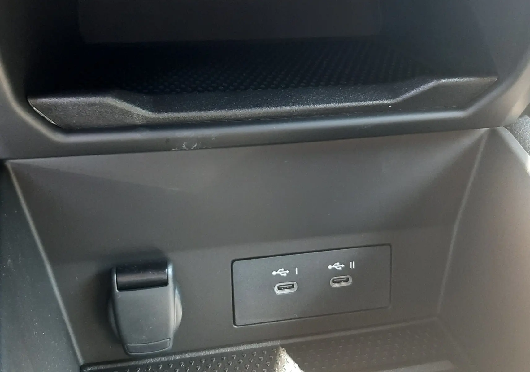 Prise USB-C double et prise 12V dans le rangement central intérieur du Renault Symbioz gris Cassiopée.