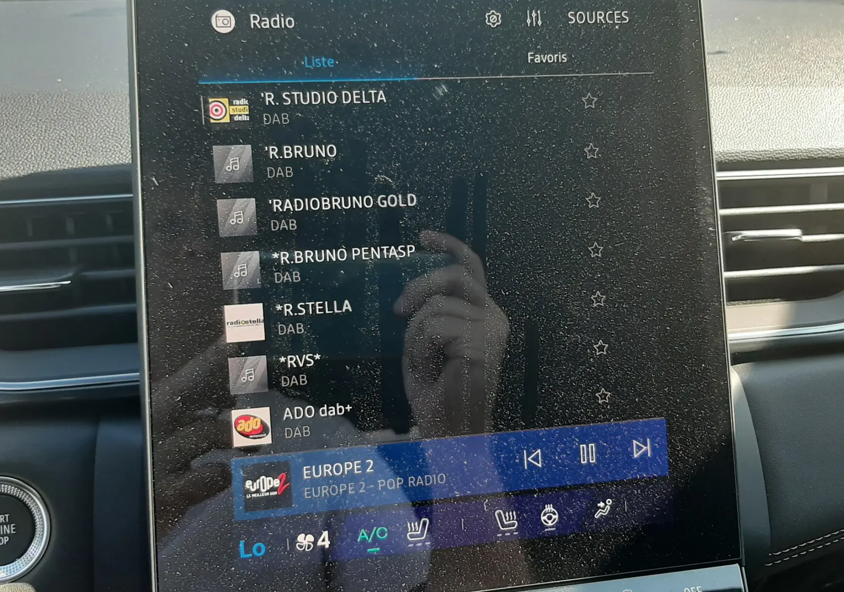 Écran tactile multimédia du tableau de bord du Renault Symbioz gris cassiopée, affichant les stations radio DAB.