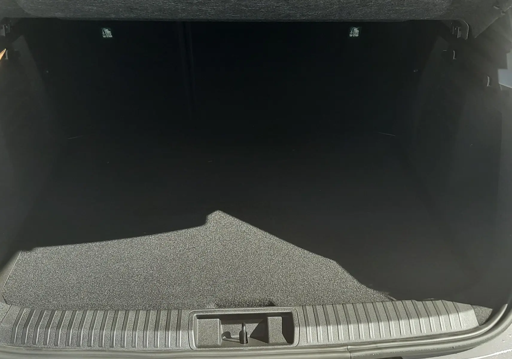 Coffre ouvert vu de l'arrière d'une Renault Symbioz gris Cassiopée, montrant un espace de chargement vide et propre.