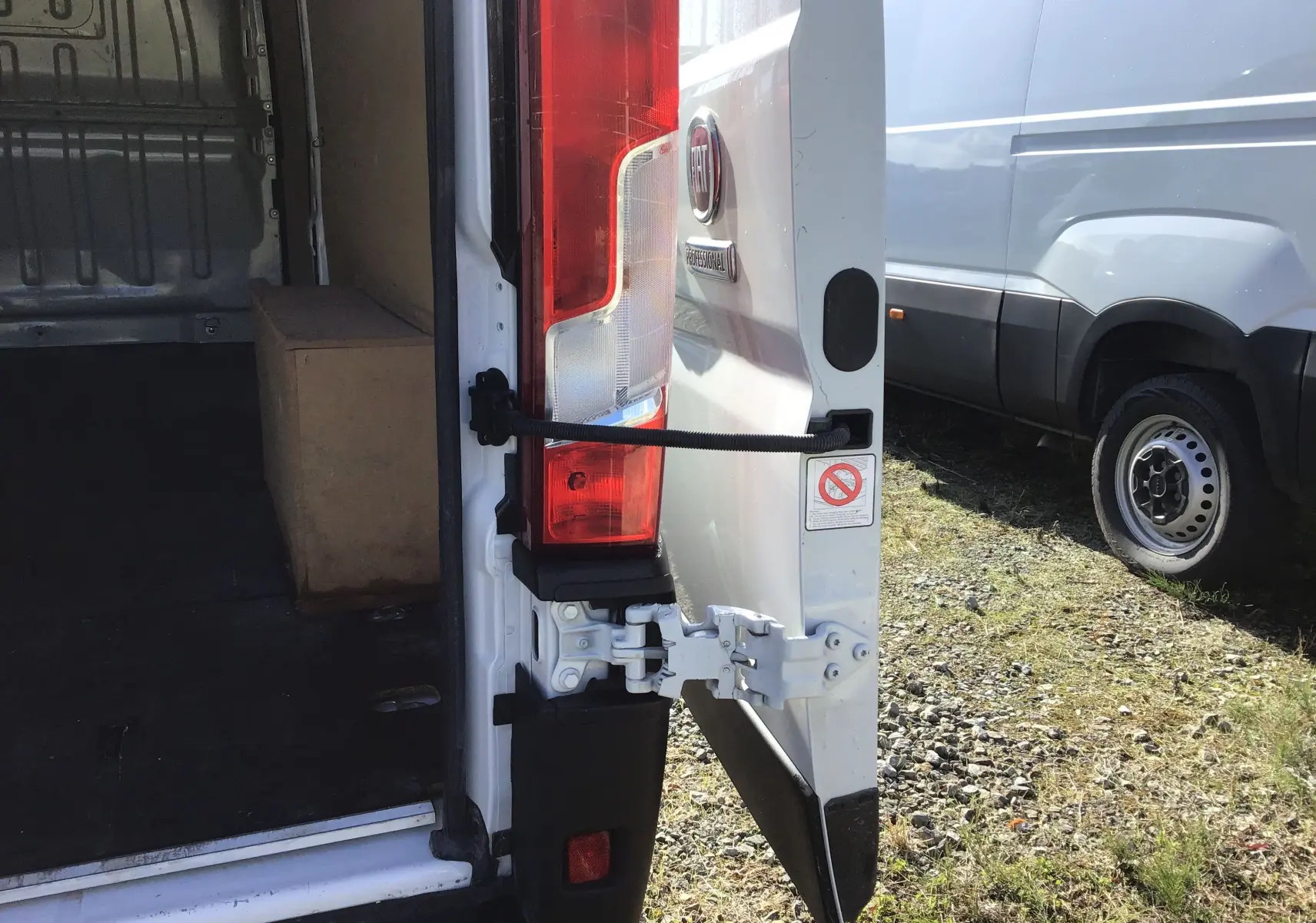 Vue arrière droite du FIAT Ducato Fourgon blanc 2024 avec porte ouverte montrant l'intérieur vide et le feu arrière.