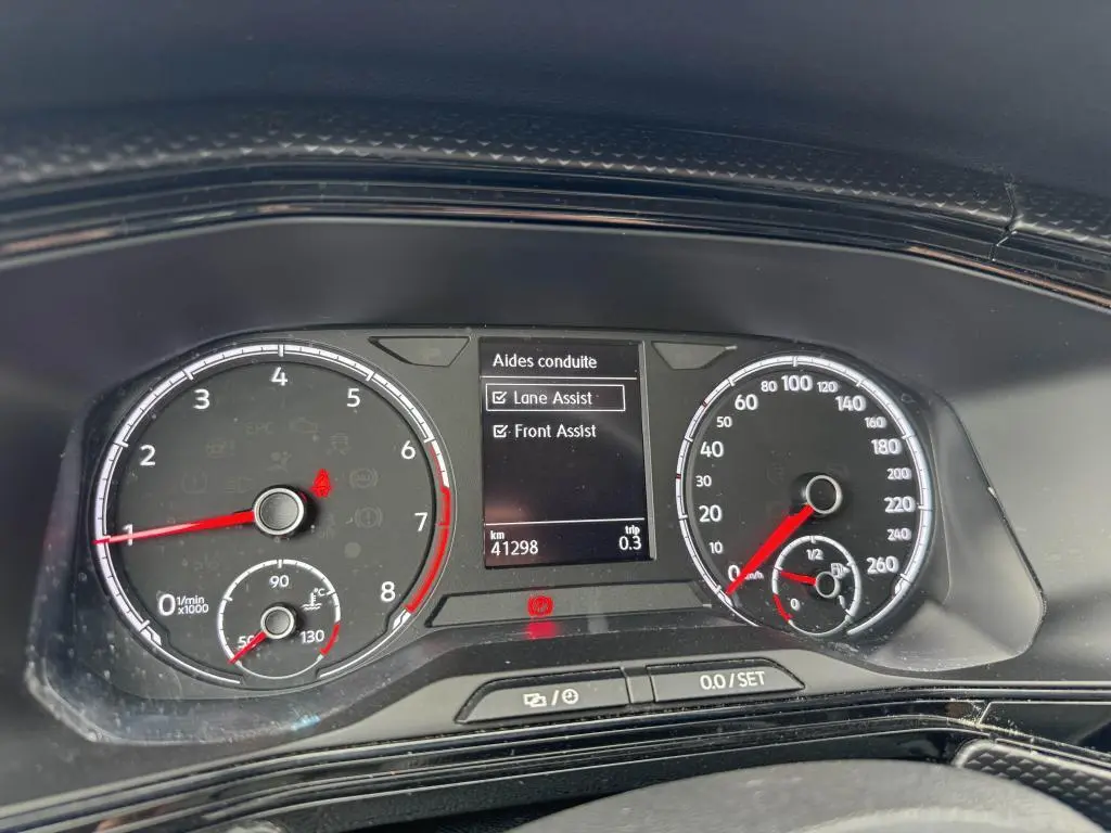 Tableau de bord numérique du Volkswagen T-cross 1.0 TSI 110 Active affichant les aides à la conduite Lane Assist et Front Assist.