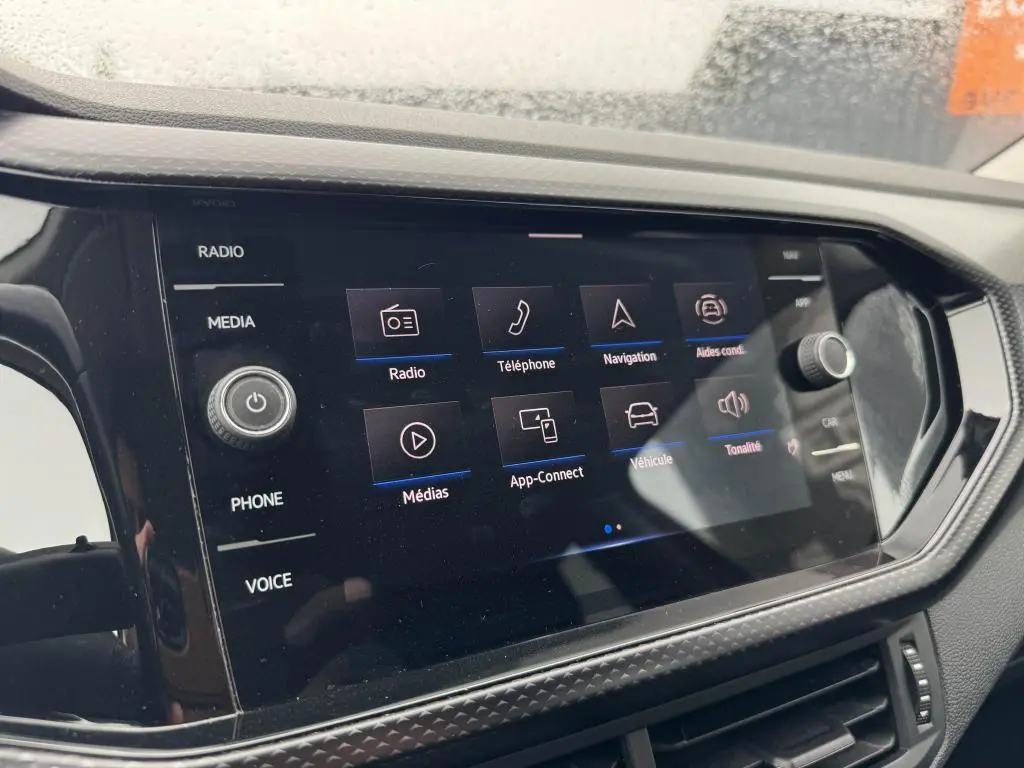 Écran tactile 8 pouces du Volkswagen T-Cross 2021 affichant les menus radio, téléphone, navigation et aides à la conduite.