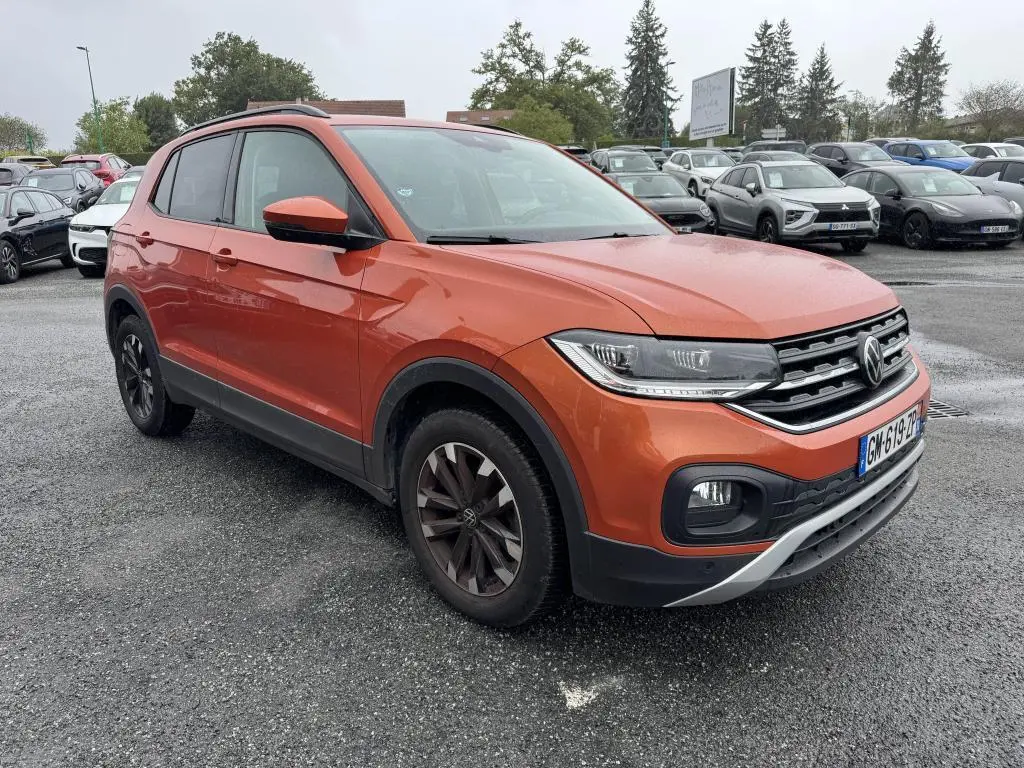 Volkswagen T-Cross orange métallisé vue 3/4 avant droit avec jantes alliage et calandre chromée.