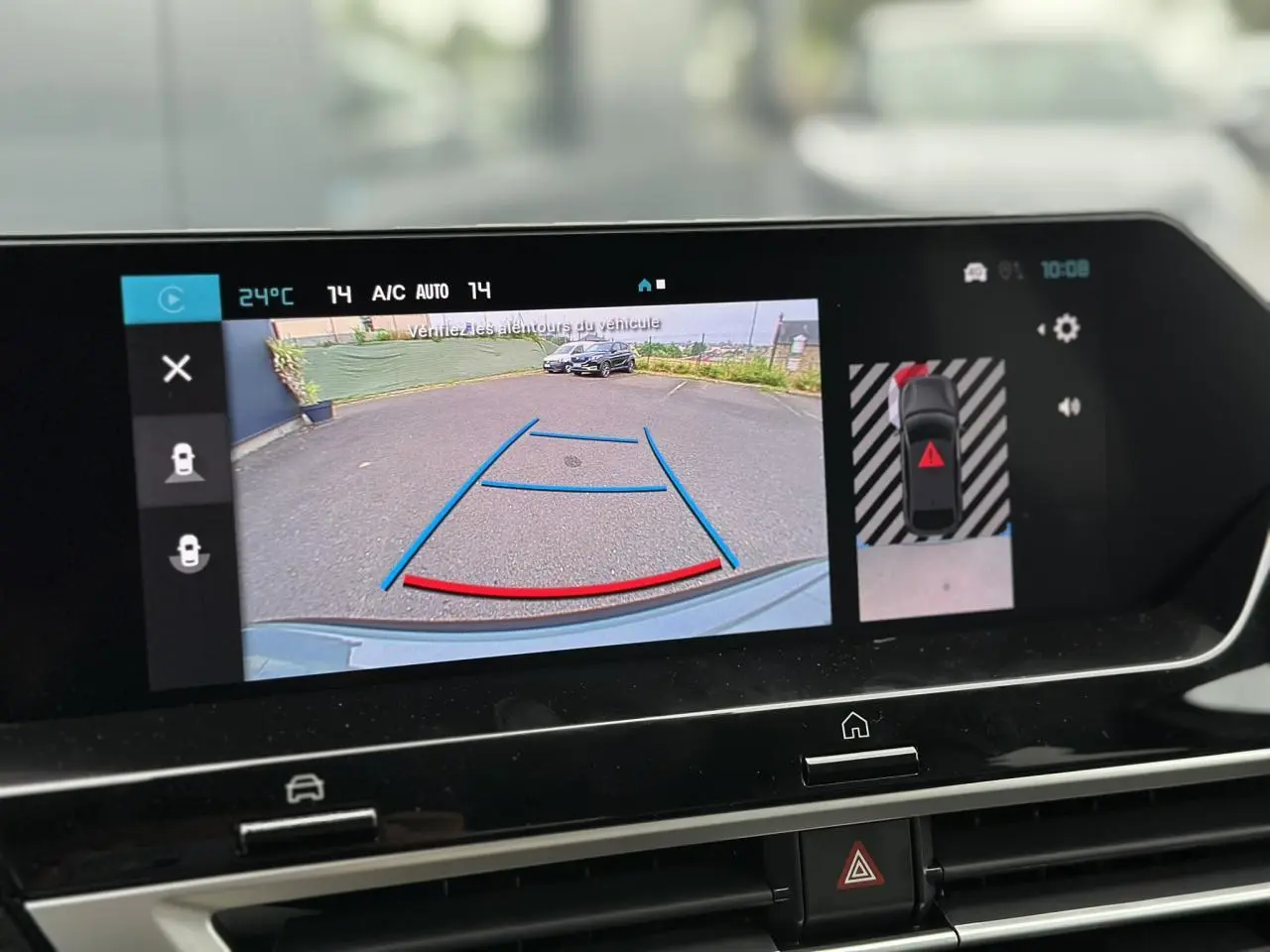 Écran tactile montrant la caméra de recul du Citroën C4 Manhattan Green avec guidage de trajectoire en bleu et rouge.