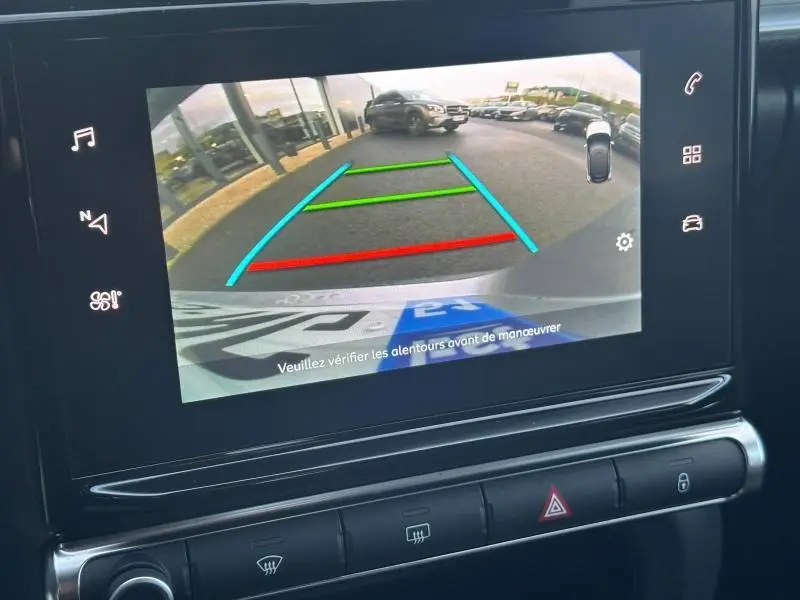 Vue arrière via caméra de recul du tableau de bord d'une Citroën C3 grise 2023, avec lignes de guidage colorées.