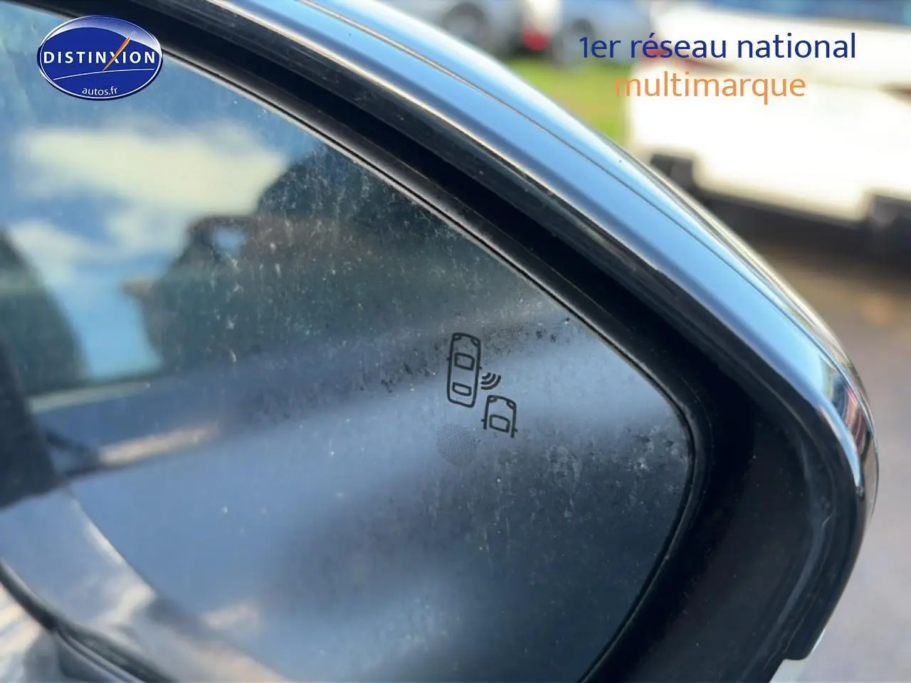 Gros plan sur le rétroviseur droit noir du Peugeot 508 Hybrid gris titane, avec icône d'alerte angle mort visible.