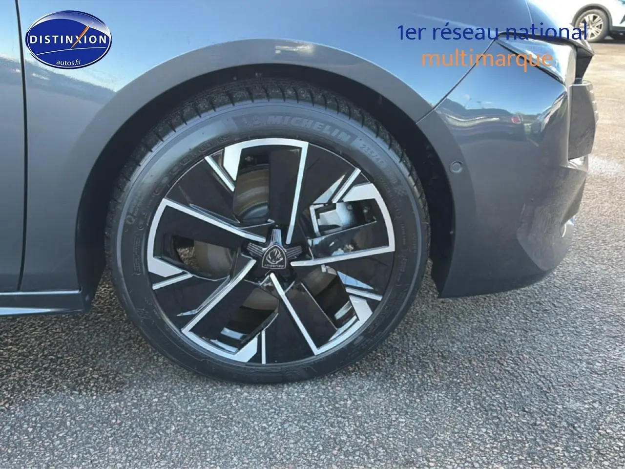 Gros plan sur la roue avant gauche de la Peugeot 508 Hybrid 225 GT e-EAT8 gris titane avec jante alu noire et argent.