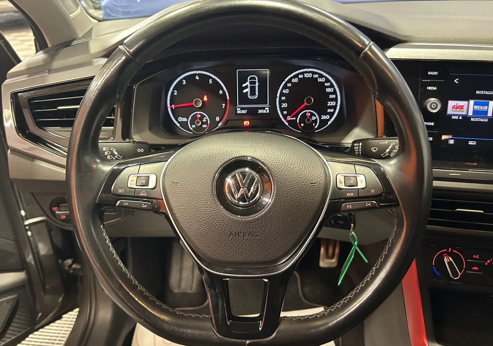 Vue centrée sur le volant en cuir noir de la Volkswagen Polo 2018, avec tableau de bord et écran tactile visibles.