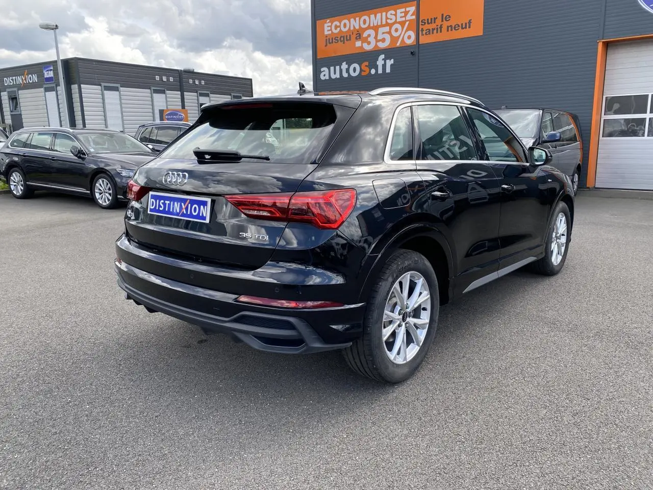 Audi Q3 noir intense métallisé vue 3/4 arrière droit, avec jantes argentées et logo 35 TDI visible sur le hayon.