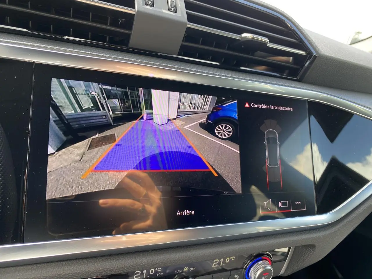 Écran central affichant la caméra de recul avec guidage, dans l'habitacle d'un Audi Q3 noir intense métallisé.