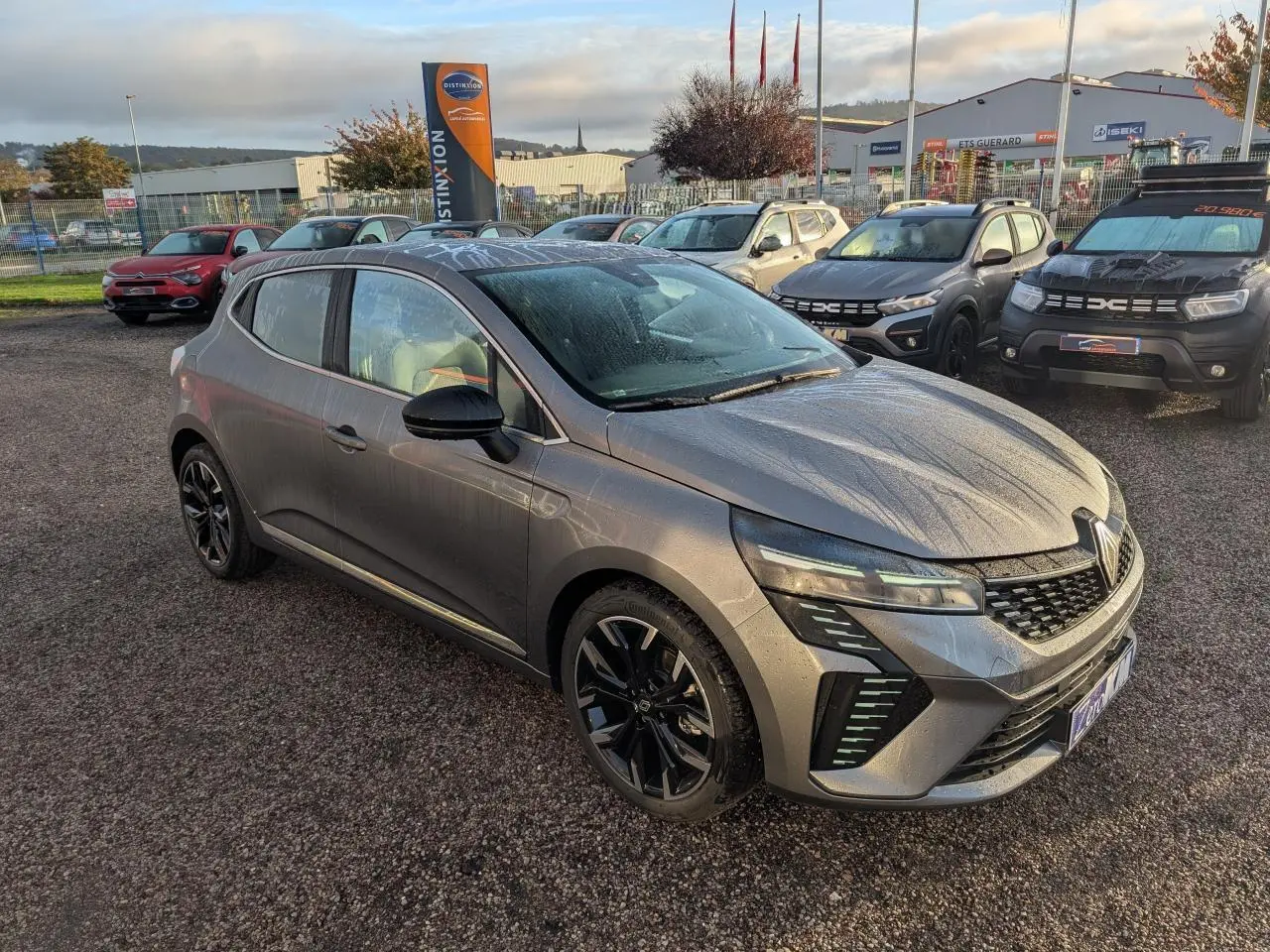 Renault Clio 2025 gris schiste vue 3/4 avant droit avec jantes alliage noires et détails chromés extérieurs