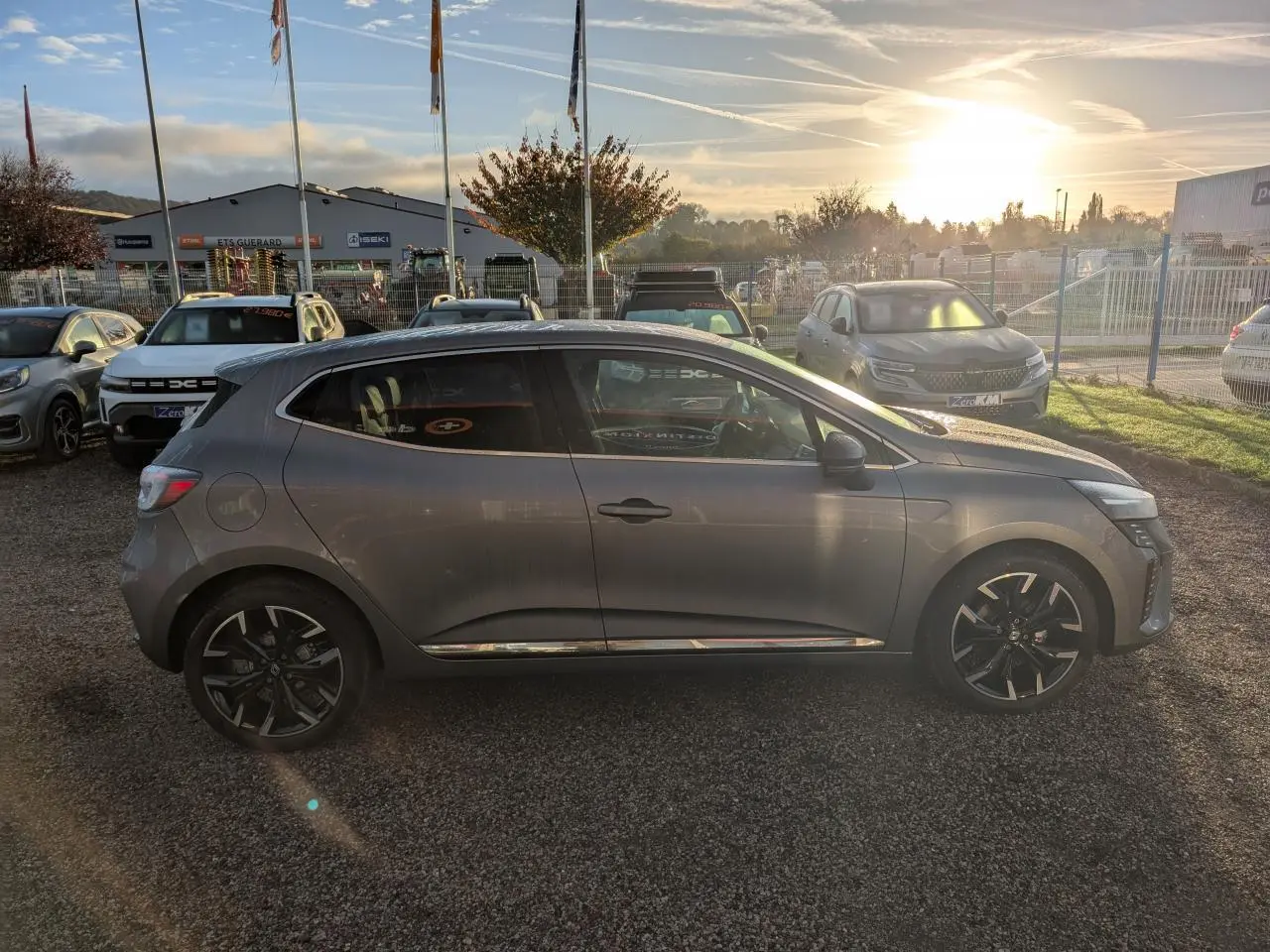 Profil côté droit d'une Renault Clio 2025 gris schiste avec jantes alliage noir monastella et contour de vitres chromé.