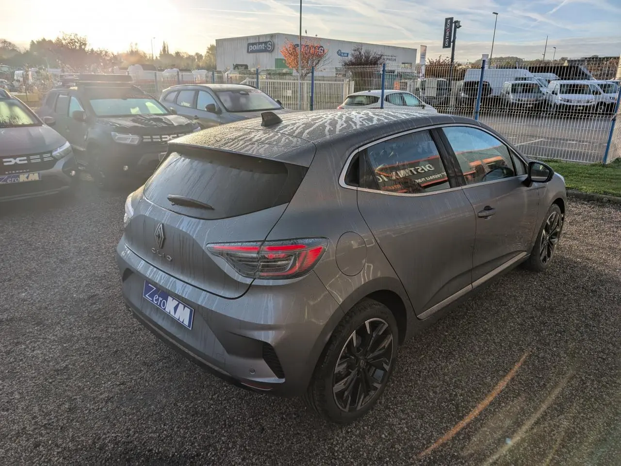 Renault Clio gris schiste vue 3/4 arrière droit, avec jantes alliage noir monastella et antenne requin noire brillante.