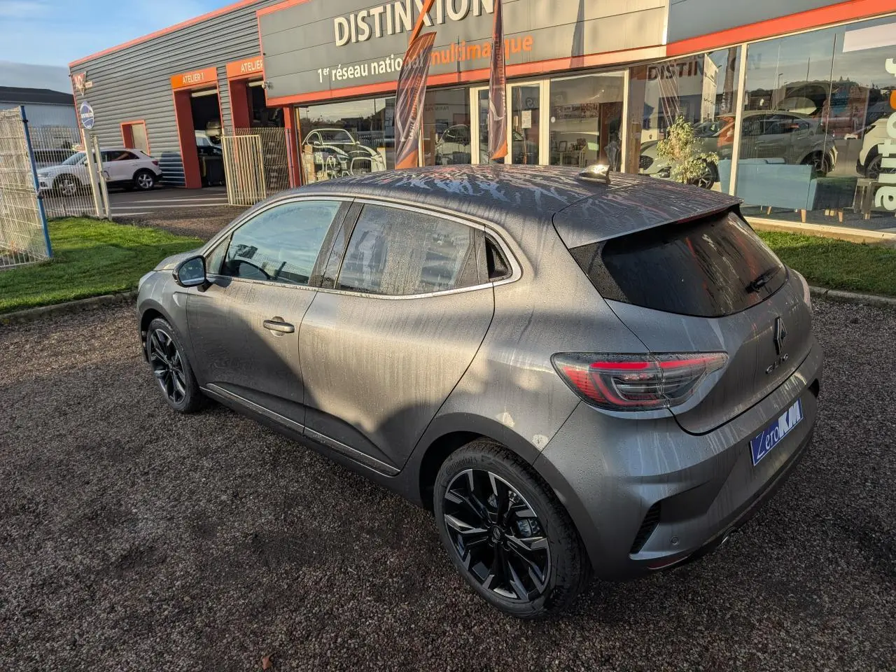 Renault Clio 2025 gris schiste vue 3/4 arrière droit avec jantes alliage noir monastella et vitres surteintées.