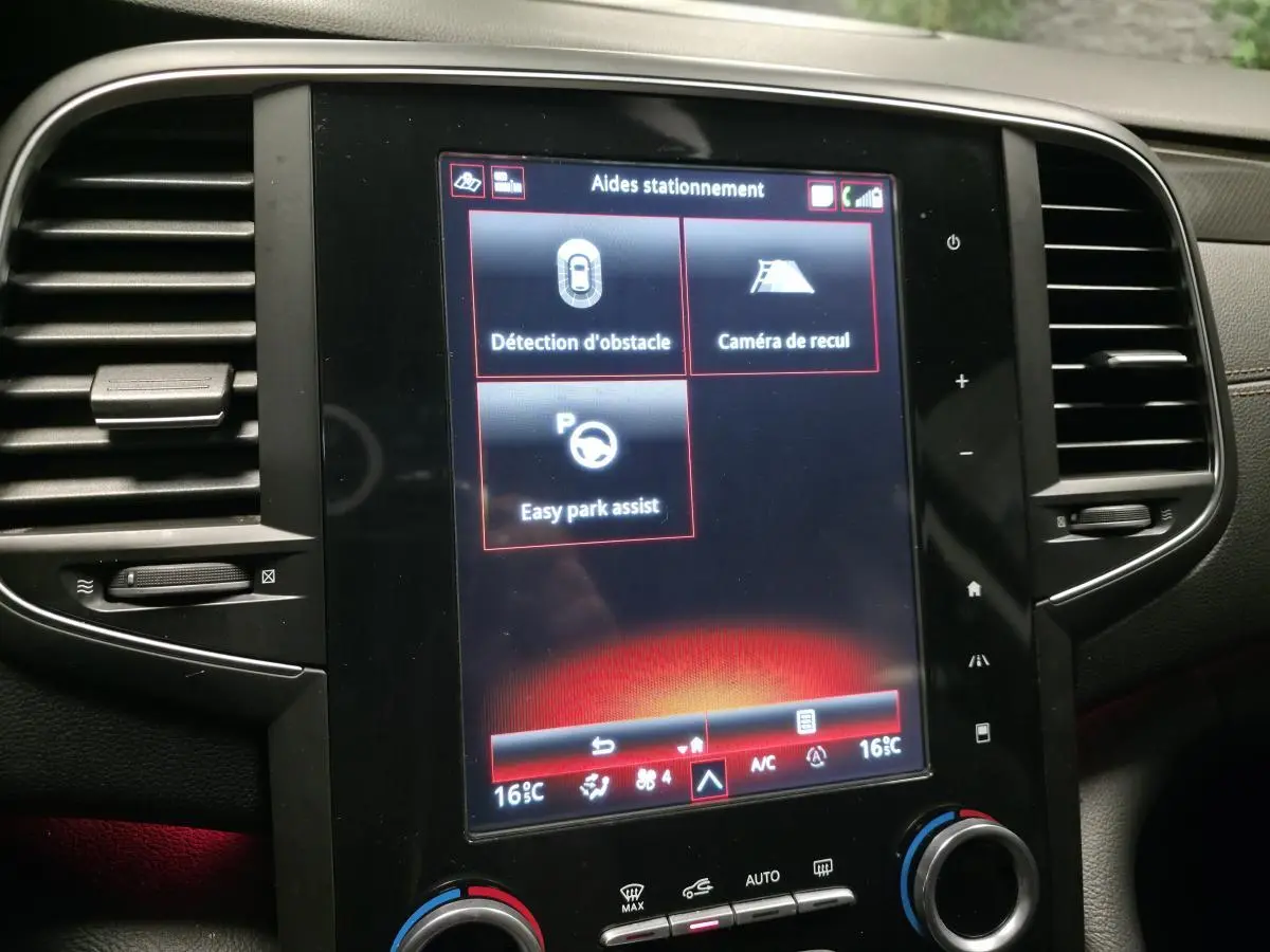 Écran tactile central de la Renault Talisman Estate gris montrant les aides au stationnement avec éclairage d'ambiance rouge.