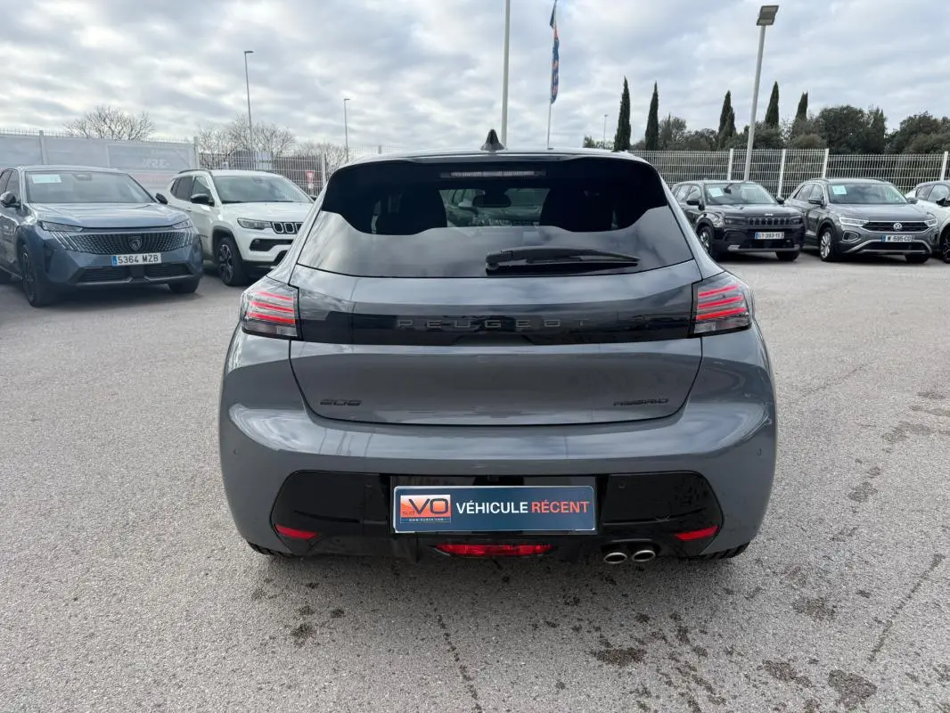 Vue arrière d'une Peugeot 208 Hybrid 145 gris métallisé avec feux LED et double sortie d'échappement visible.