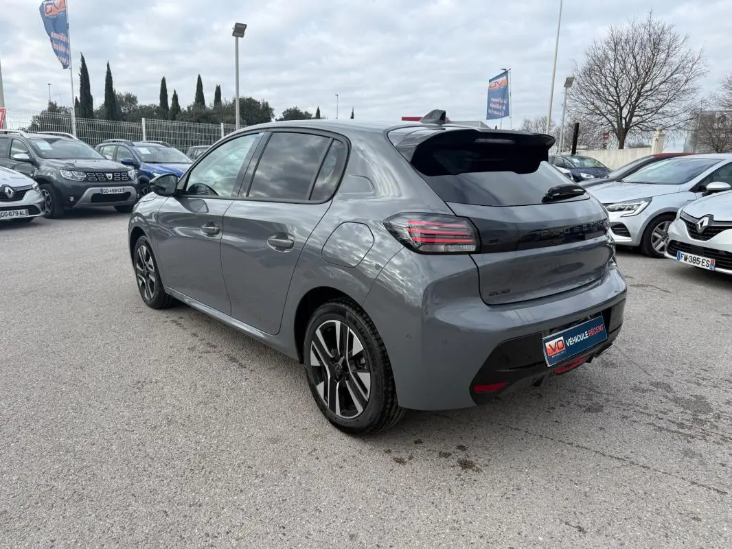 Peugeot 208 Hybrid 145 gris vue 3/4 arrière droit, avec jantes alliage 16 pouces et antenne requin noire.
