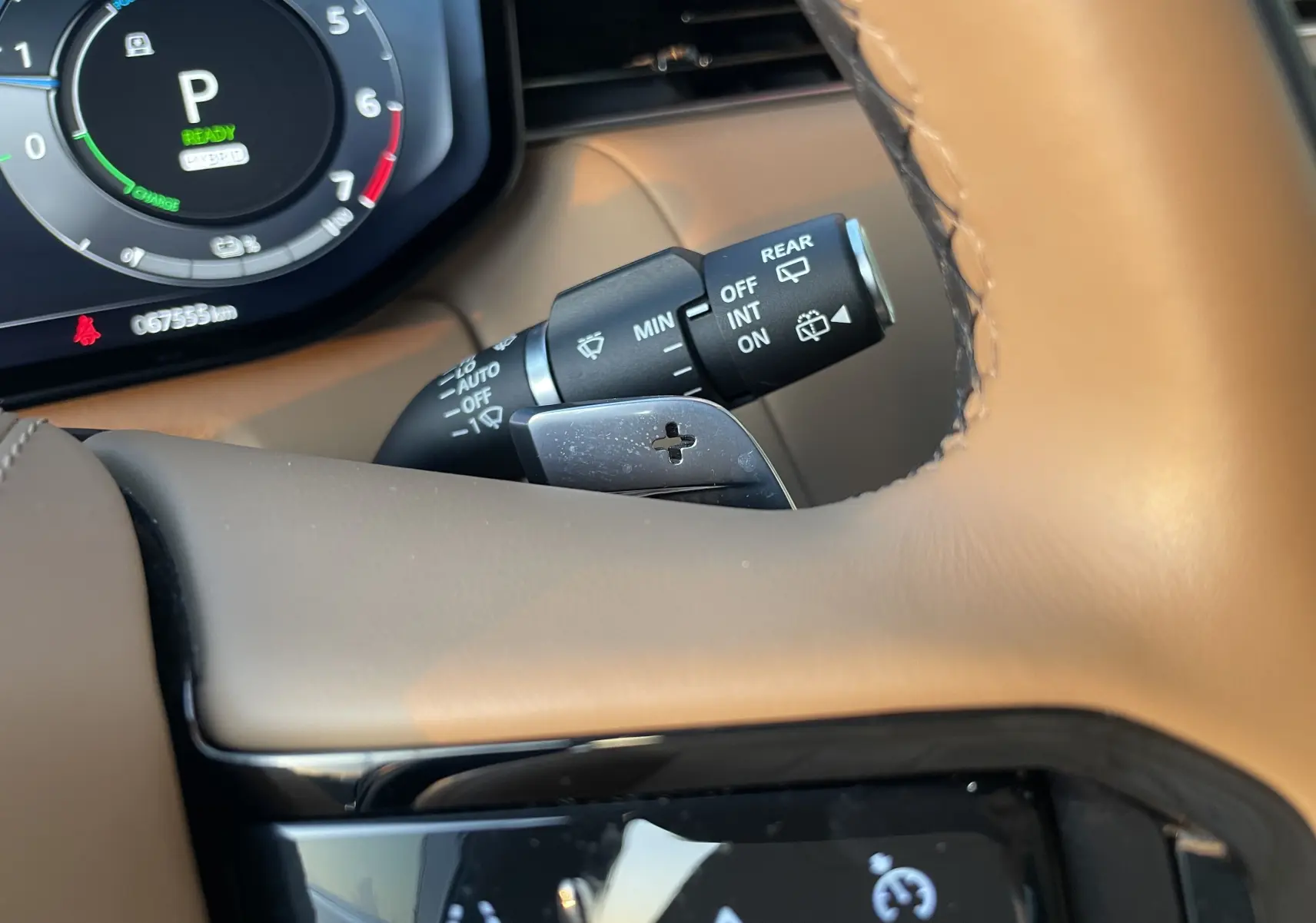 Gros plan sur le volant beige du Range Rover Sport P440 HSE R-Dynamic avec palettes de changement de vitesse et tableau de bord numérique.