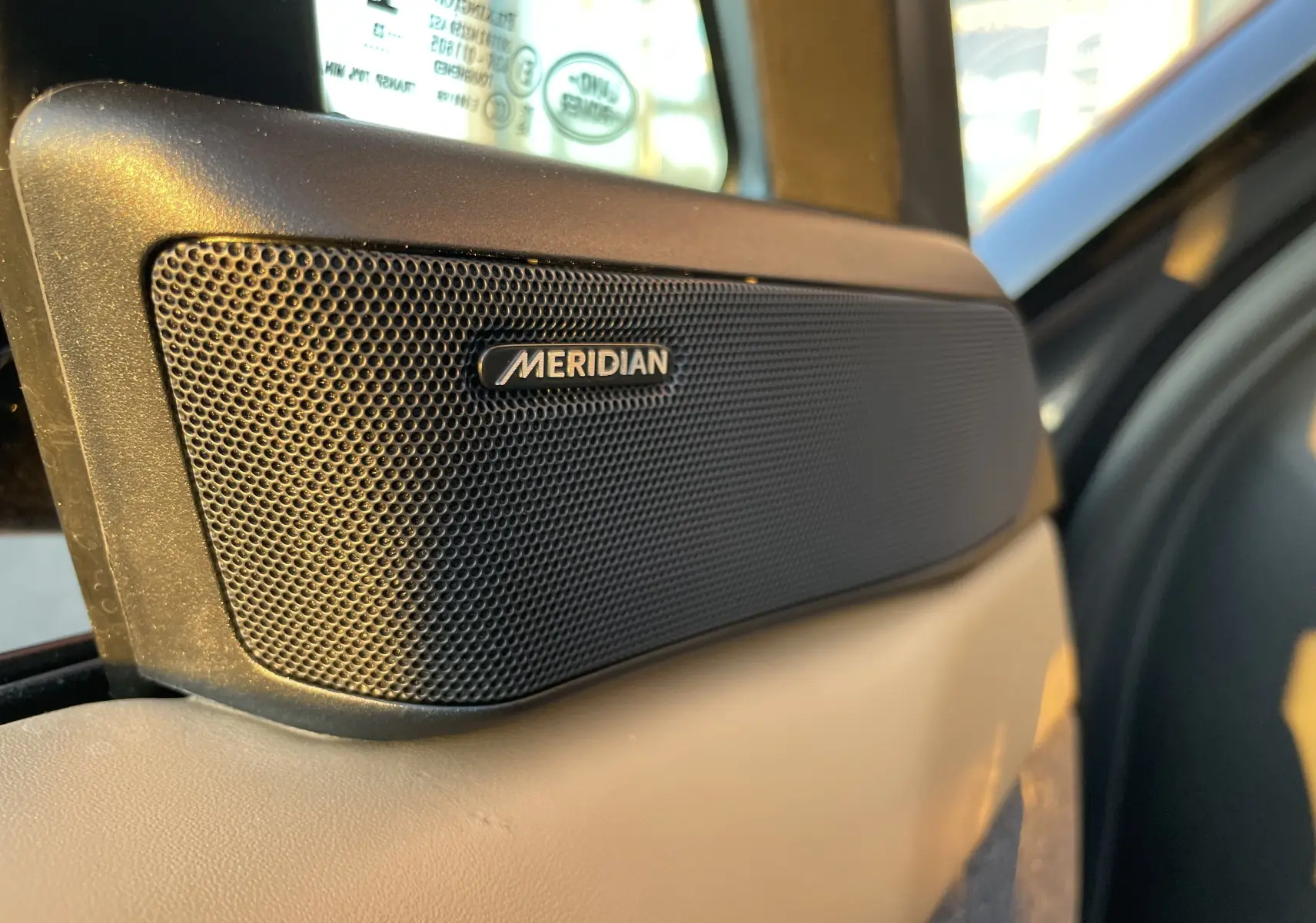 Gros plan sur l'enceinte Meridian intégrée à la porte intérieure beige du Range Rover Sport P440 HSE R-Dynamic 2023.