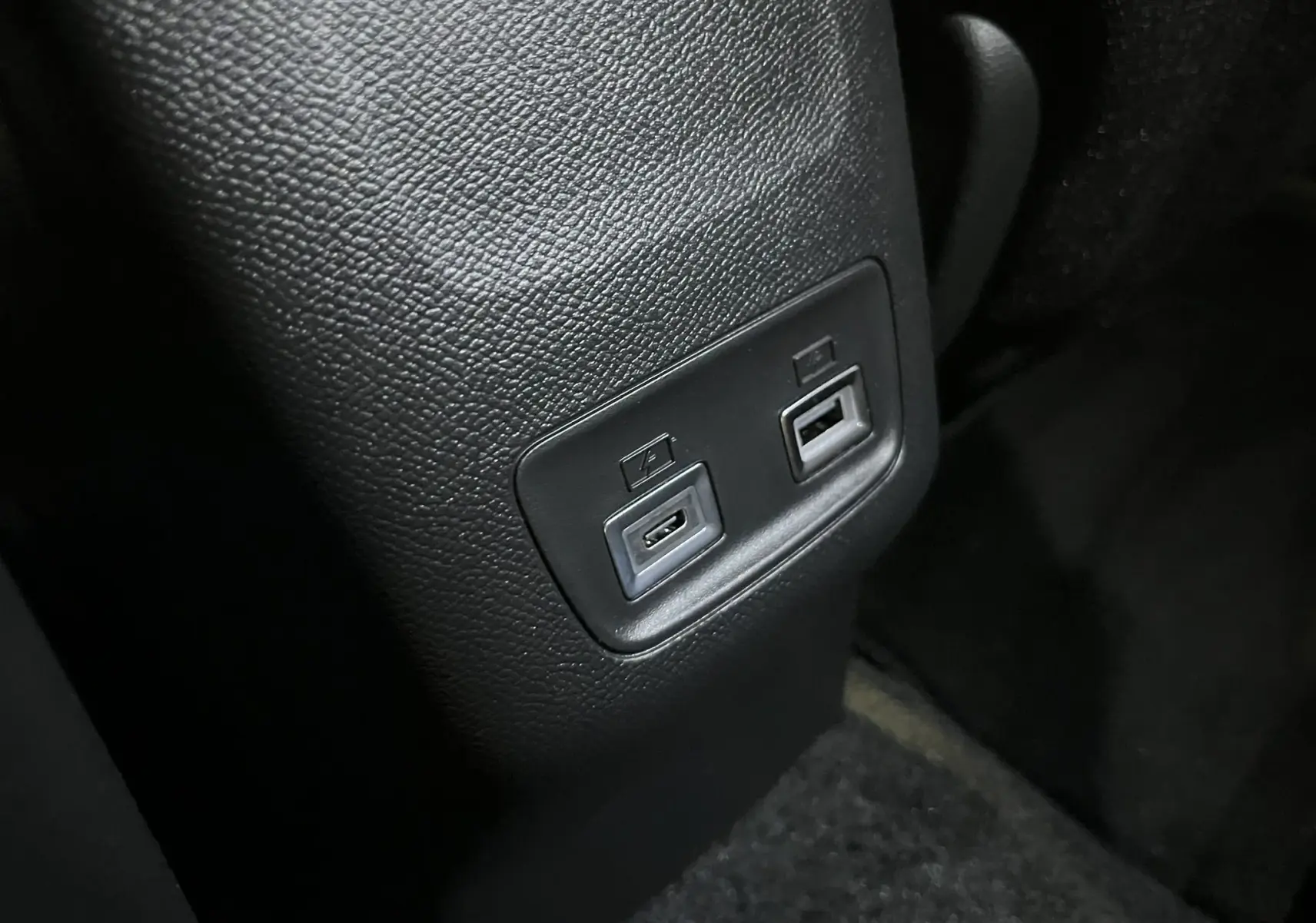 Gros plan sur les ports USB arrière intégrés dans la console centrale noire du Peugeot 2008 gris Artense 2025.