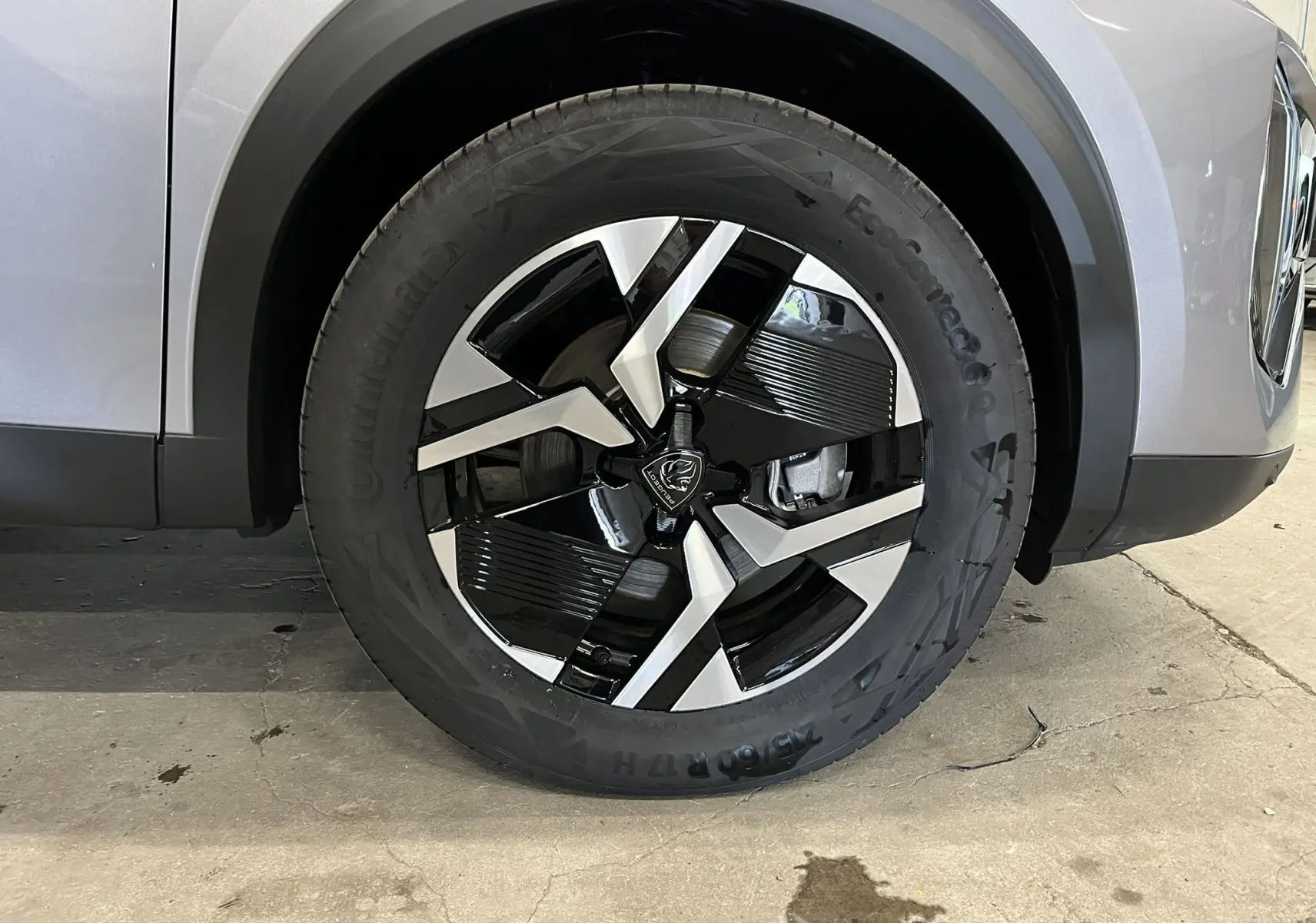 Gros plan sur la roue avant droite du Peugeot 2008 gris Artense Métal, mettant en valeur la jante bi-ton noire et argentée.