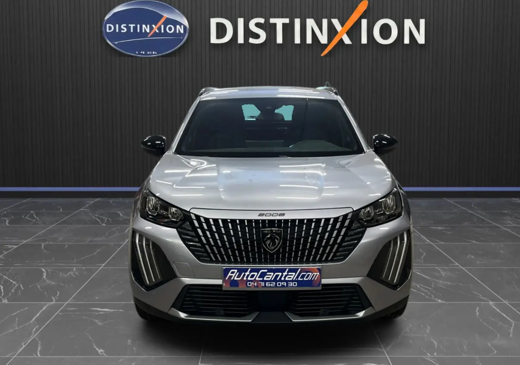 Peugeot 2008 gris Artense métal vue de face, soulignant la calandre verticale et les feux LED distinctifs.