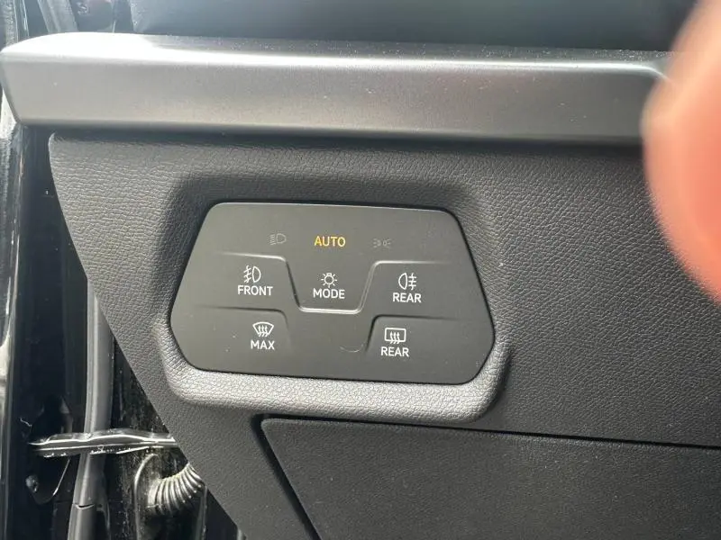 Gros plan sur les commandes d’éclairage automatiques du tableau de bord d’un CUPRA Formentor noir Minuit.