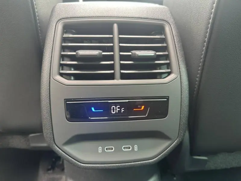 Détail de la console arrière avec bouches d’aération et commandes de climatisation éteintes dans une CUPRA Formentor noir Minuit.