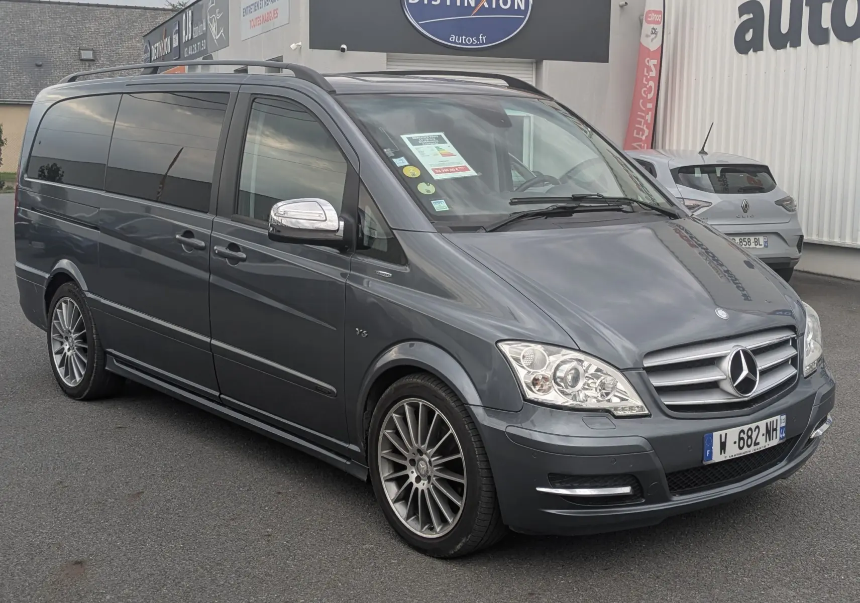 Mercedes Viano gris en 3/4 avant droit avec jantes alliage et vitres arrière surteintées, stationné devant un garage