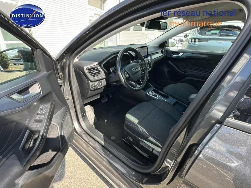 Intérieur avant gauche d'une Ford Focus Active gris foncé 2021, montrant sièges réglables et tableau de bord moderne.