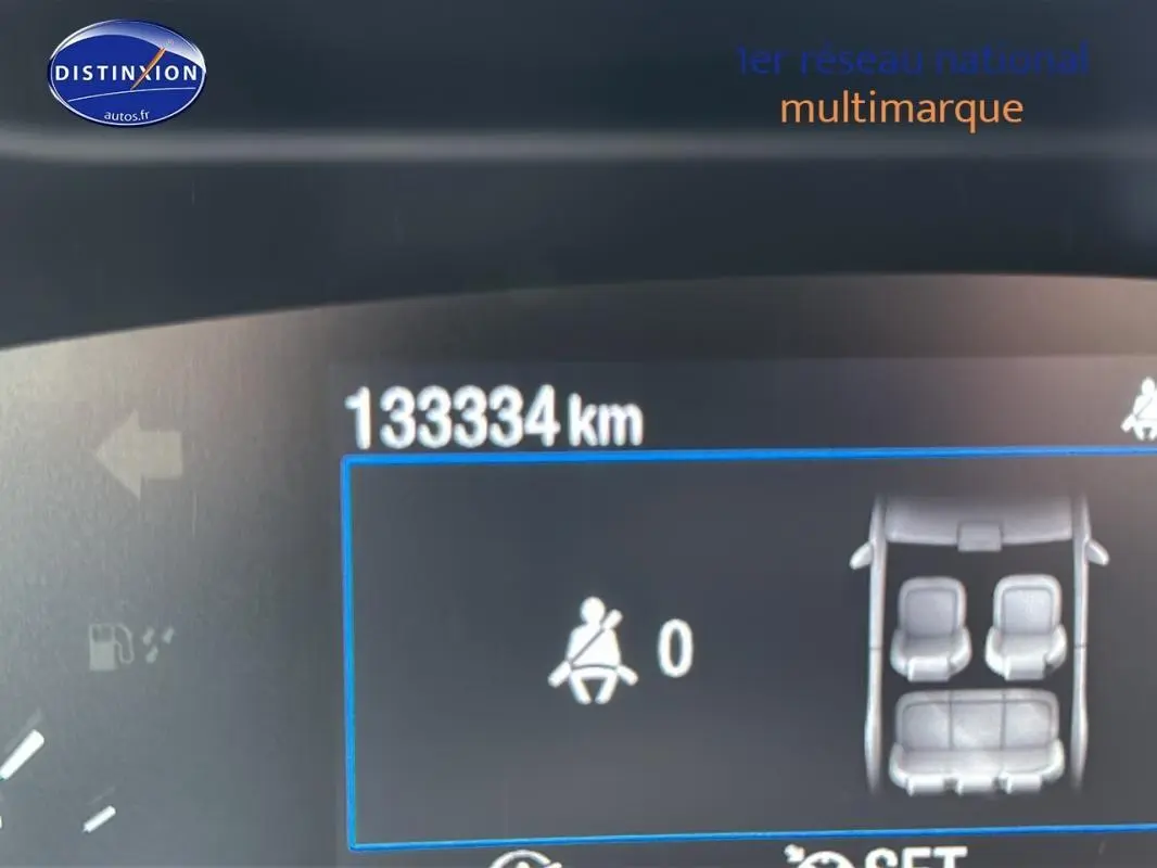 Vue rapprochée du tableau de bord numérique d'une Ford Focus Active gris foncé affichant 133334 km et l'état des ceintures.