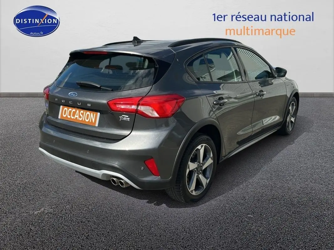 Vue 3/4 arrière droite d'une Ford Focus Active gris foncé avec barres de toit et jantes alliage 17 pouces.