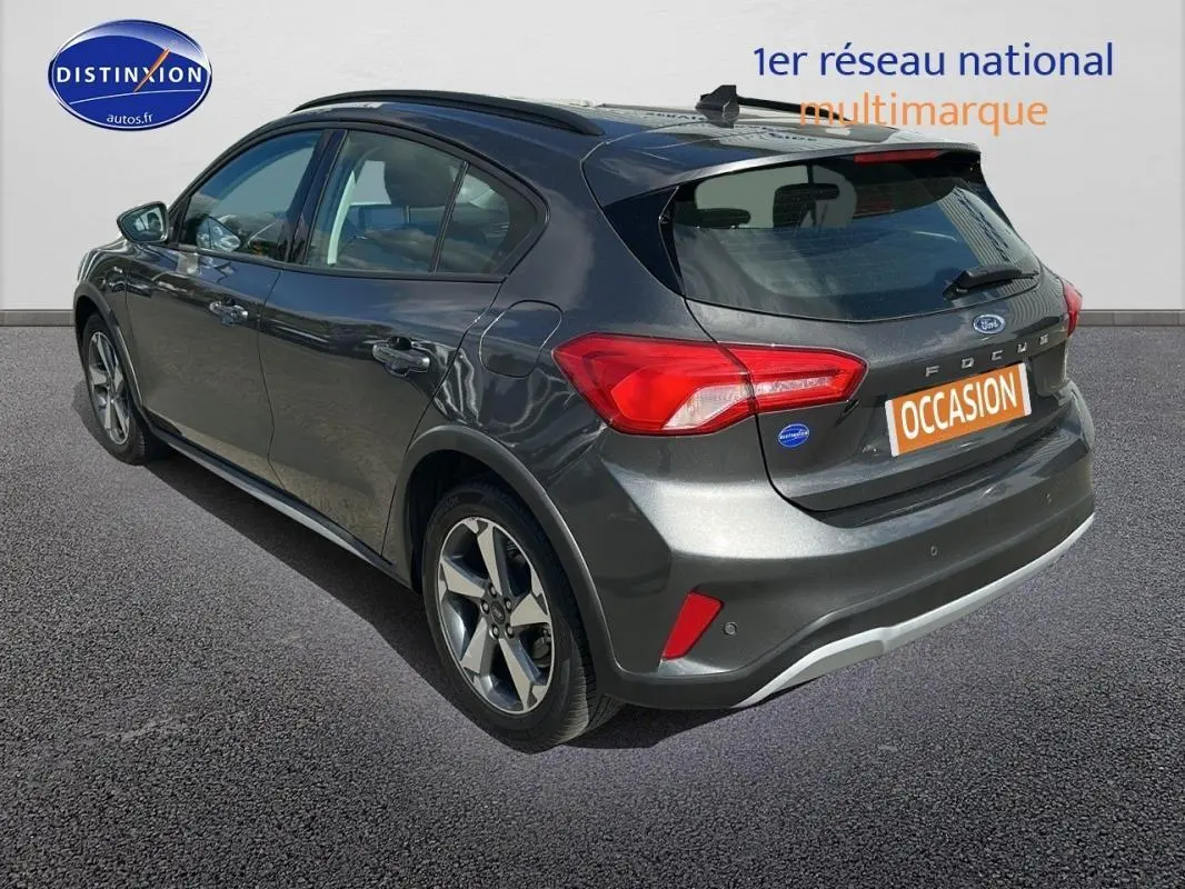 Vue 3/4 arrière droite d'une Ford Focus Active gris foncé avec barres de toit et jantes alliage 17 pouces.