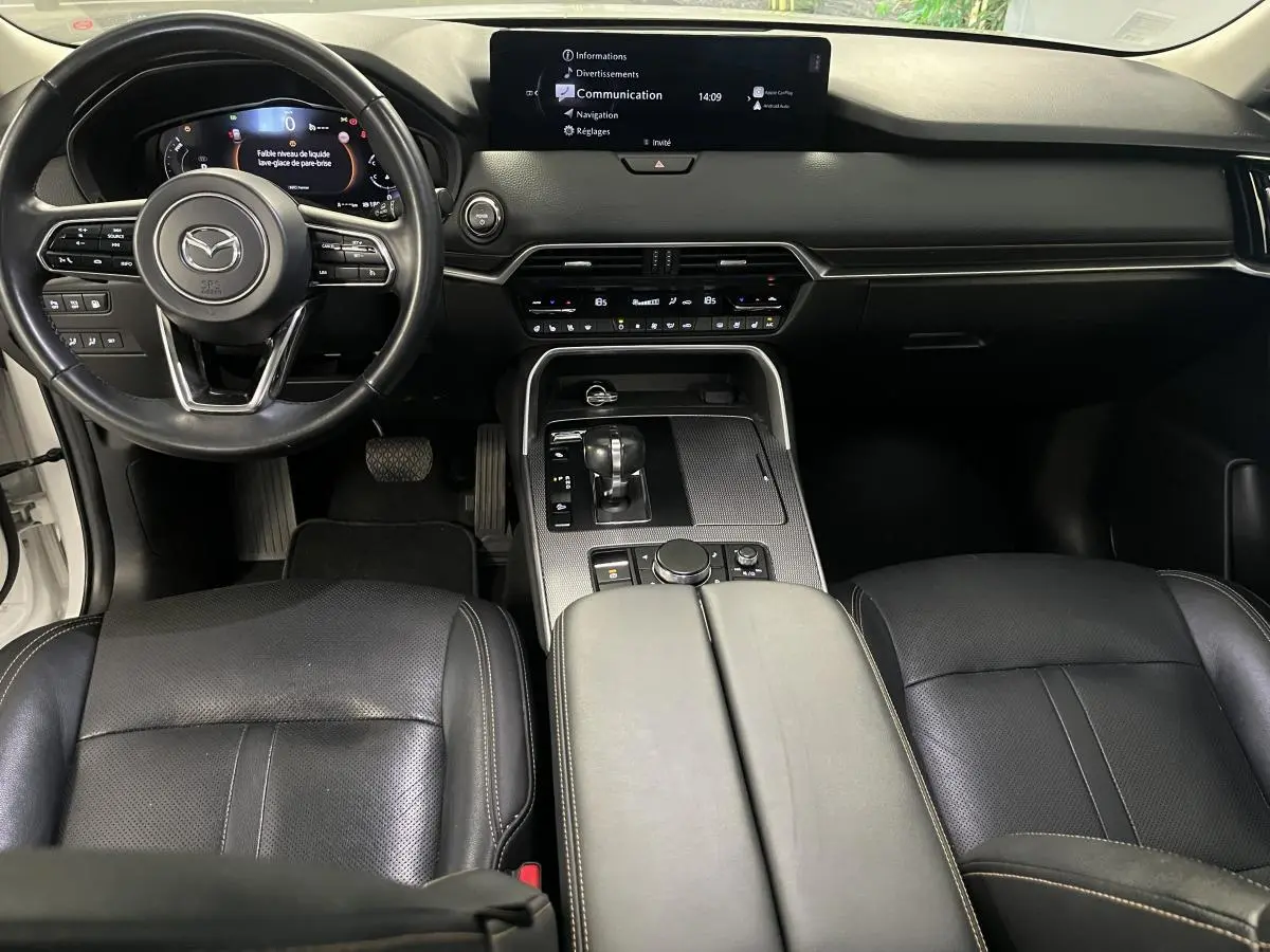 Intérieur noir cuir du Mazda CX-60 2023, vue avant centrée sur tableau de bord et console centrale.