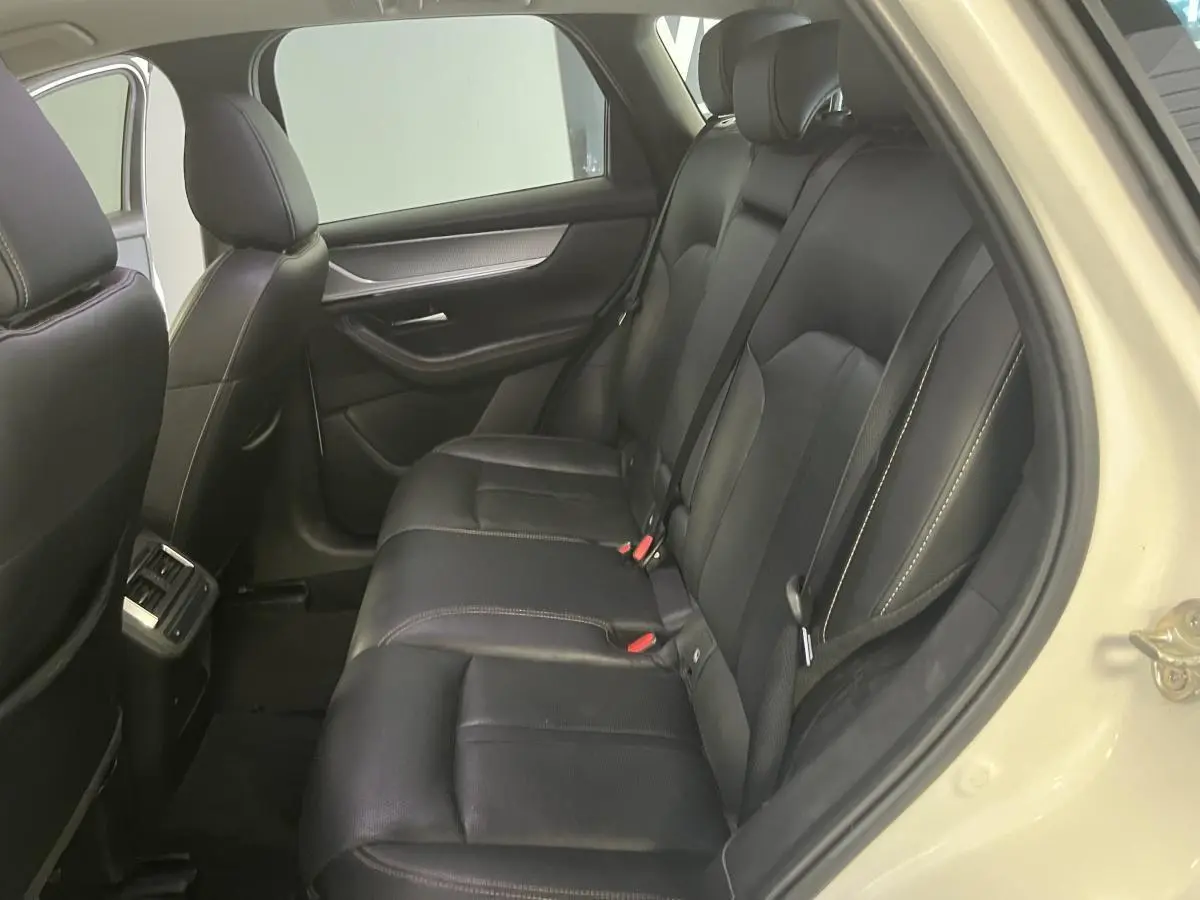 Vue intérieure côté droit des sièges arrière en cuir noir avec surpiqûres bronze du Mazda CX-60 blanc 2023 Homura.