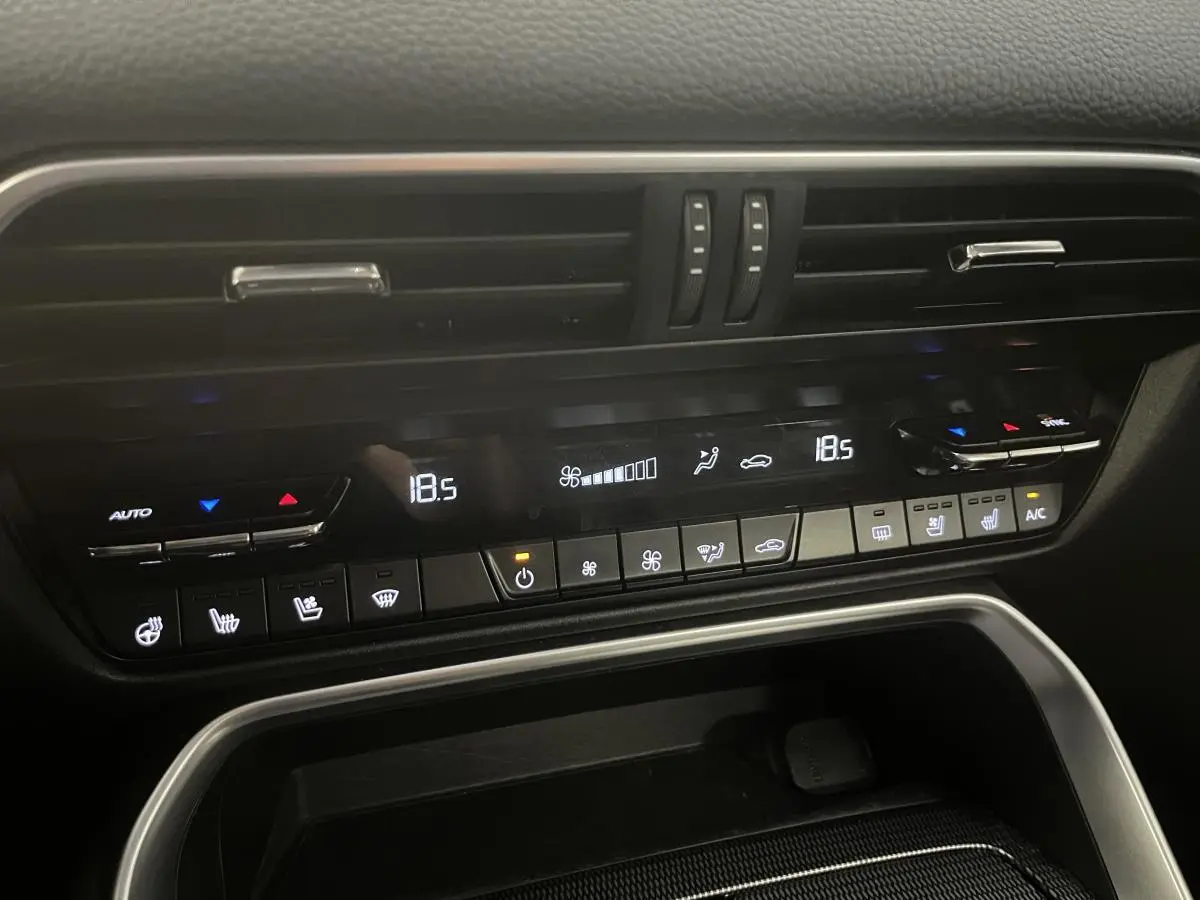 Panneau de commande de la climatisation bi-zone du Mazda CX-60 blanc 2023, avec affichage digital et commandes tactiles.