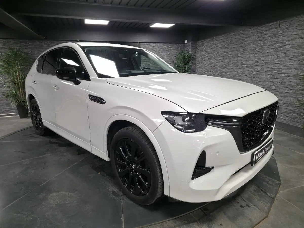 Vue 3/4 avant droite du Mazda CX-60 blanc Arctic White avec jantes alliage noires et calandre Piano Black.