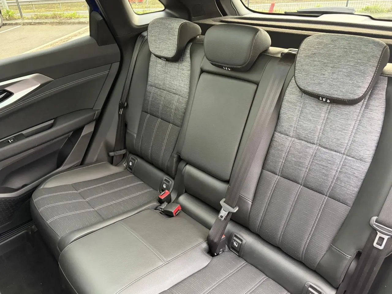 Vue côté droit de la banquette arrière mixte tissu et cuir gris du Renault Austral E-Tech 2025 avec appuie-têtes ajustables.