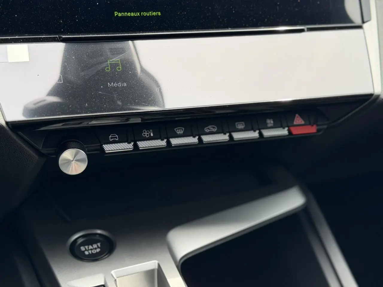 Vue rapprochée de la console centrale de la Peugeot 308 gris Artense, avec boutons de commande et bouton start/stop visible.
